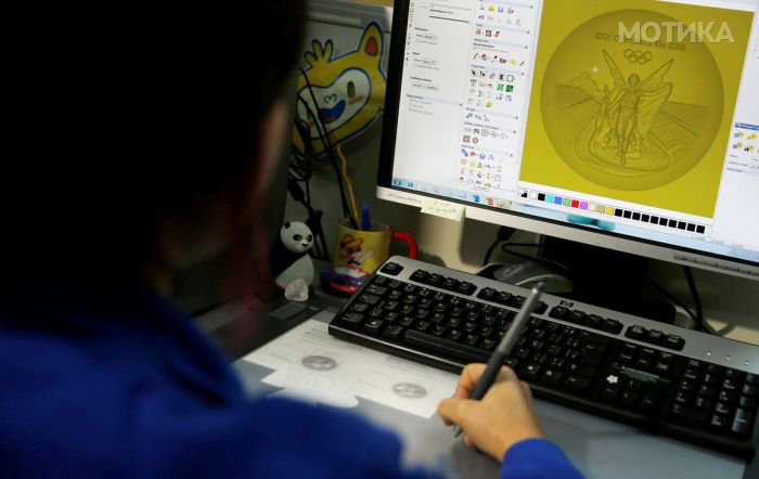 A sculptress from the Casa da Moeda do Brasil (Brazilian Mint) works on the Rio 2016 Olympic medal at her computer in Rio de Janeiro