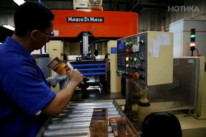 A worker from the Casa da Moeda do Brasil (Brazilian Mint) checks plates to prepare the Rio 2016 Olympic and Paralympic medals in Rio de Janeiro