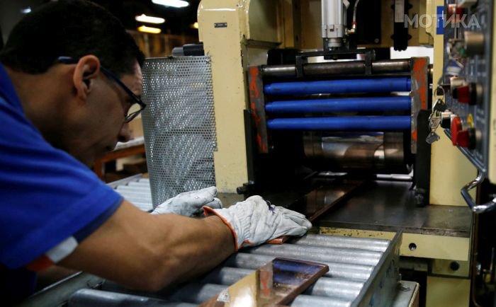 A worker from the Casa da Moeda do Brasil (Brazilian Mint) puts plates to prepare the Rio 2016 Olympic and Paralympic medals in Rio de Janeiro