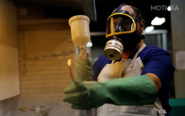 A worker from the Casa da Moeda do Brasil (Brazilian Mint) varnishes a Rio 2016 Olympic medal in Rio de Janeiro