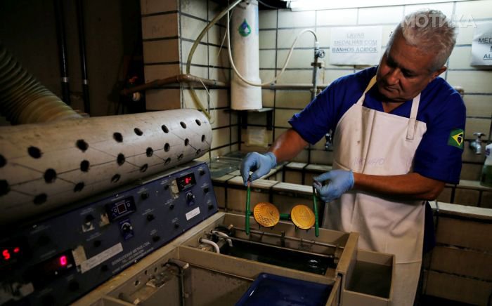 A worker from the Casa da Moeda do Brasil (Brazilian Mint) takes out gold-plates Rio 2016 Olympic and Paralympic medals in Rio de Janeiro