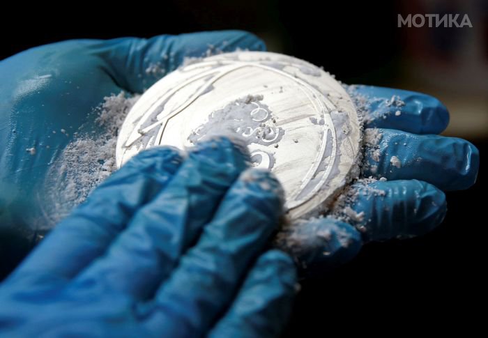 A worker from the Casa da Moeda do Brasil (Brazilian Mint) cleans a Rio 2016 Olympic medal in Rio de Janeiro