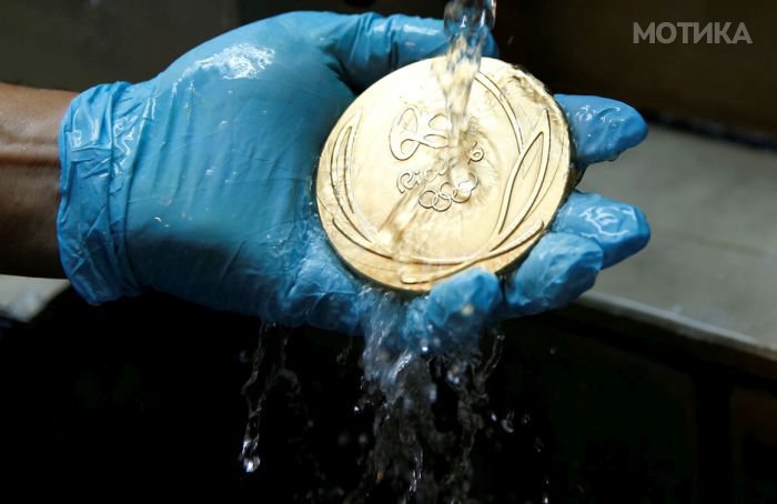 A worker from the Casa da Moeda do Brasil (Brazilian Mint) cleans a Rio 2016 Olympic medal in Rio de Janeiro