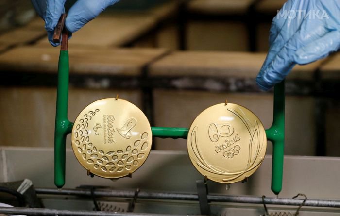 A worker from the Casa da Moeda do Brasil (Brazilian Mint) takes out gold-plated Rio 2016 Olympic and Paralympic medals in Rio de Janeiro