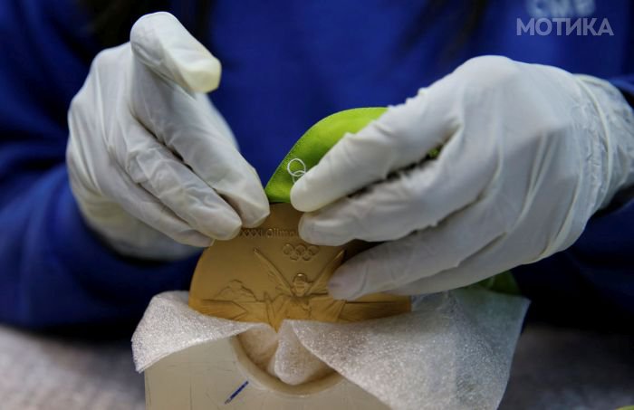 A worker from the Casa da Moeda do Brasil (Brazilian Mint) prepares a Rio 2016 Olympic medal in Rio de Janeiro